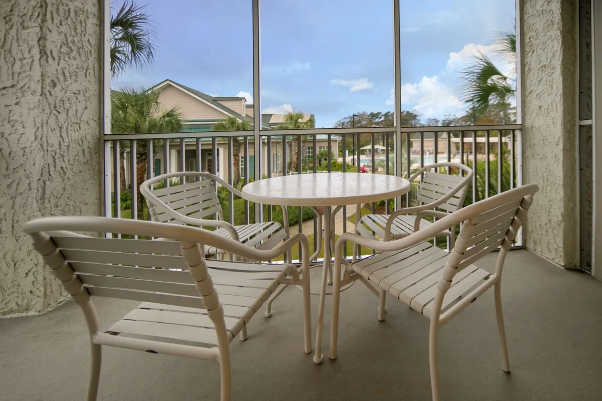 This interior image focuses on a dining table and chairs, with a view outside visible through nearby windows. The mood is casual and relaxed, evoking a space where people can gather, enjoy meals, and socialize together. The setting suggests a comfortable area suitable for breakfast, dinner, or simply relaxing with a view.